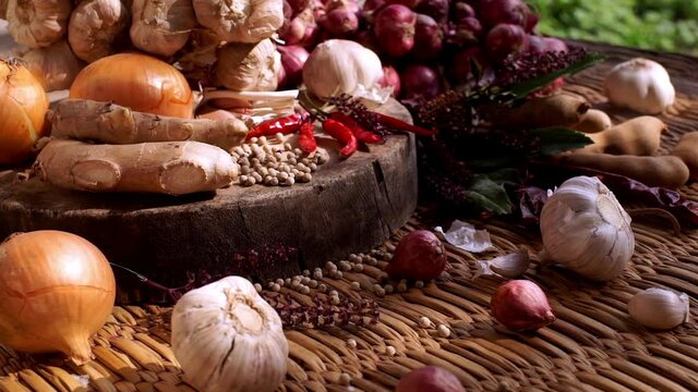 South East Asian seasoning spices and herbals ingredients for making hot and spices food varieties arranged beautifully on a wooden cutting board on a kitchen table in an afternoon sunlight