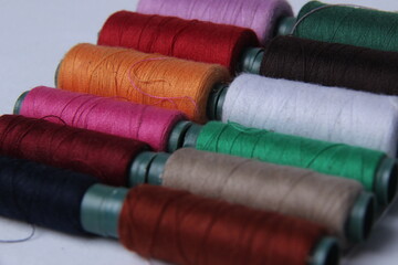 colorful sewing thread that is isolated white background.  collection of threads for fabric