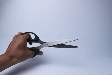 hands holding open scissors against a white background