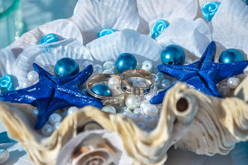 Shell wedding rings with pearls and starfish. Wedding decor in a marine style.