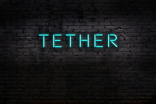 Neon sign. Word tether against brick wall. Night view