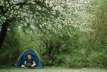 Communicate with relatives, family online on laptop in tent in nature. Man briefing the team at the conference or remote work consultation, man worker speak talk on video call with colleagues.