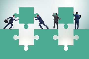 Businessman in teamwork concept with jigsaw puzzle