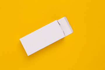 Open White packing box on yellow background. Minimalism. Top view