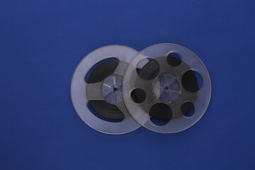 Audio magnetic tape. Two Film reel on classic blue background. Top view. Retro style. 80s