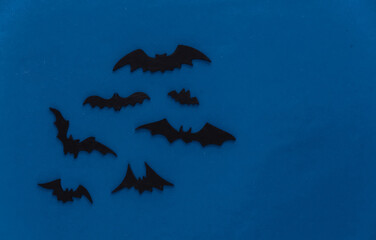 Halloween background, decorations and scary concept. Black bats fly over blue dark night background, copy space