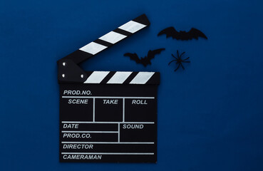 Horror movie, halloween theme. Movie clapperboard, spiders and flying decorative bats on classic...