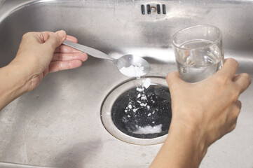 pour a spoon of baking soda and a glass of vinegar respectively into the drain of the sink , kitchen tips for effectively get rid of unpleasant smell - obrazy, fototapety, plakaty