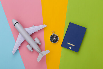 Compass, passport and air plane on colored background. Travel, adventure flat lay. Top view