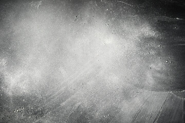 Scattered cloud of white flour on slate background