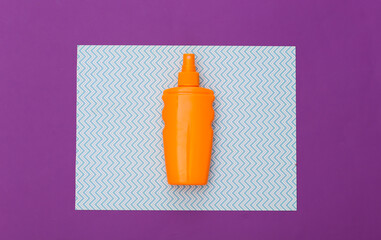 Beach vacation. Sunblock bottle, starfish on blue purple background. Top view. Flat lay
