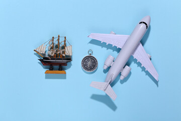 Compass, ship and air plane on bright blue background. Travel, adventure flat lay. Top view