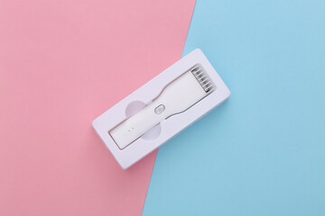 New Wireless Hair Clipper in packaging on pink blue pastel background. Top view