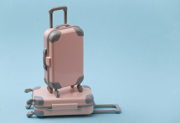 Travel, vacation or tourism concept. Two mini travel luggage suitcase on a blue background