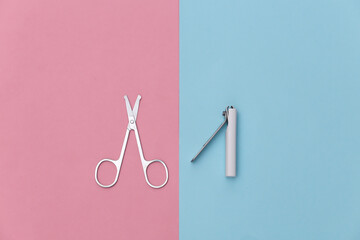 Manicure scissors, nail clippers on pink blue background. Beauty concept. Nail care. Top view