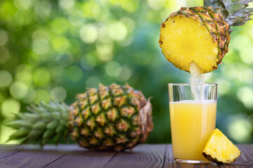 Fototapeta na wymiar pineapple juice pouring into glass