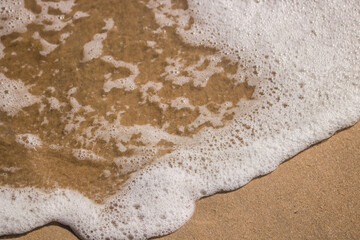 White sea foam in a beach.