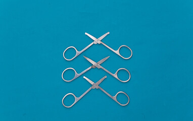 Three Manicure scissors on blue background. Beauty concept. Nail care. Top view