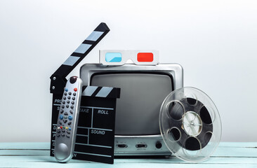 Old tv receivers with movie clapperboard, film reel, 3d glasses on white wall background. Entertainment Industry, media, filmmaking