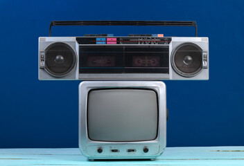 Retro tv receiver with audio tape recorder on a classic blue background. Retro media