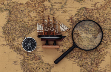 Compass and magnifying glass, ship on old map. Travel, adventure concept