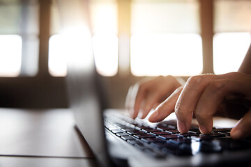 Young Woman Typing Computer Laptop Keyboard. Closeup shot and Selective focus on Finger. Working on...