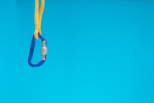 Blue carabiner and a climbing rope, Equipment for belaying in climbing and mountaineering.