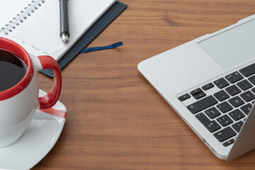 student table with computer, a notepad with pen and a coffee