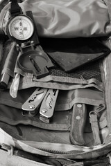 Fototapeta na wymiar Compass, knife and multitool in a backpack