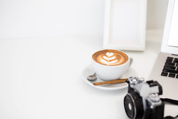 coffee cup and camera on table in home.