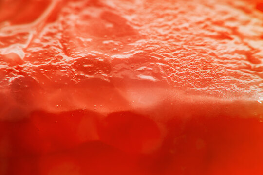 Background with sliced tomato under strong magnification in soft focus. A detailed image of the pulp of a ripe tomato.