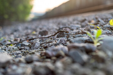 Blurred background with gravel, railroad tracks and standing freight train.