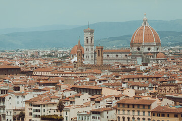 Fototapeta na wymiar top aerial panoramic view of Florence city with cathedral, buildings houses with orange red tiled roofs and hills range, blue sky white clouds, Tuscany, Italy