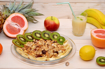 healthy breakfast with muesli and fruits and a glass of juice on a wooden background