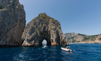 Panorama of Capri with  the beautiful Faraglioni and boasts passing trought the famous arch, South of Italy.