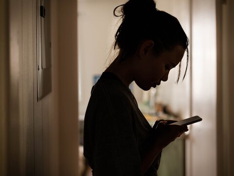 Serious woman looking at her phone at home stressed.