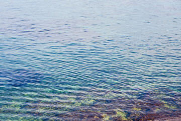 Texture of a clear transparent tropical Sea water  on the coast of Crete, Greece as a natural background.