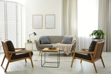 Modern living room interior with comfortable sofa and armchairs