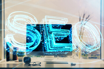 Double exposure of table with computer and seo drawing hologram. Search optimization concept.