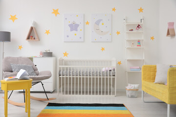 Stylish baby room interior with crib, rocking chair and sofa