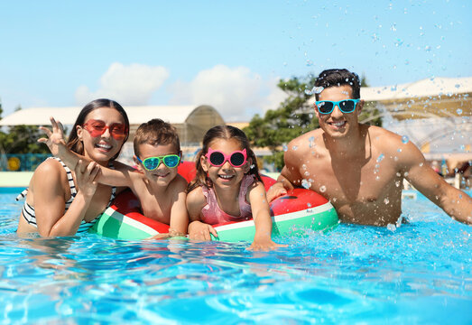 Happy family in swimming pool. Summer vacation