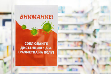 A poster with warning text in russian about safety requirements due to coronavirus outbreak  at the entrance to the pharmacy, the coronavirus pandemic of COVID-19 in Russia. Russian text