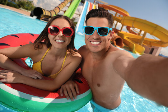 Happy couple taking selfie at water park. Summer vacation