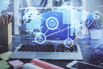 Computer on desktop with social network hologram. Double exposure. Concept of international people connections.