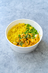 Take Away Indian Street Food Tikka Masala with Chicken, Curry Basmati Rice, Green Peas and Coconut Milk Sauce.