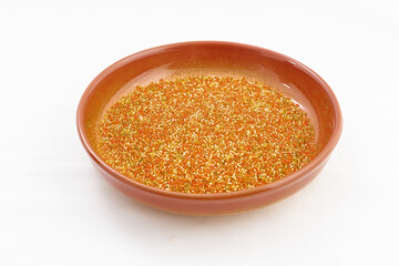 Orange plate or bowl with seed beads for handcraft, making of jewelry, embroidery, female fashion accessories isolated on white background.