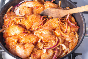 Cooking chicken with spicy sauce, Italian cuisine - Arrabbiata garlic chicken is cooked in a pan, close-up