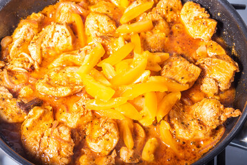 Cooking chicken with spicy sauce, Italian cuisine - Arrabbiata garlic chicken is cooked in a pan, close-up