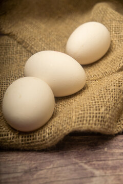 White chicken eggs on a background of homespun fabric with a rough texture. Close up.
