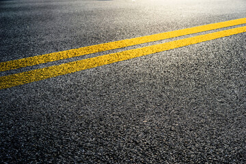 Double yellow lines on asphalt street roadway surface texture background. - obrazy, fototapety, plakaty